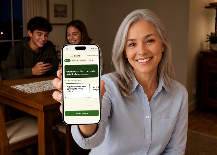 A grandmother holding up a phone showing a Cards Out Loud Family Game Night round, with two teenagers playing at the table behind her.